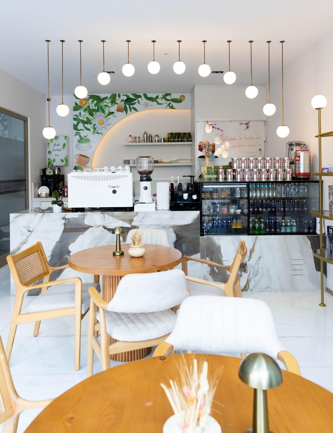 Kafe bölümündeki ahşap masa ve rattan sandalyeler