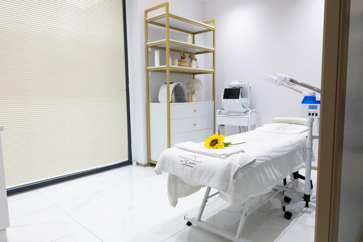 Lazer epilasyon odasındaki cihaz ve altın rengi raf ünitesi